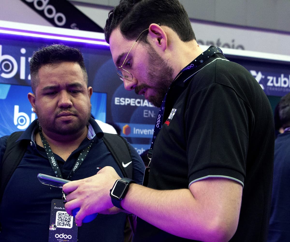 Integrante de R&R muestra una solución a un asistente del evento